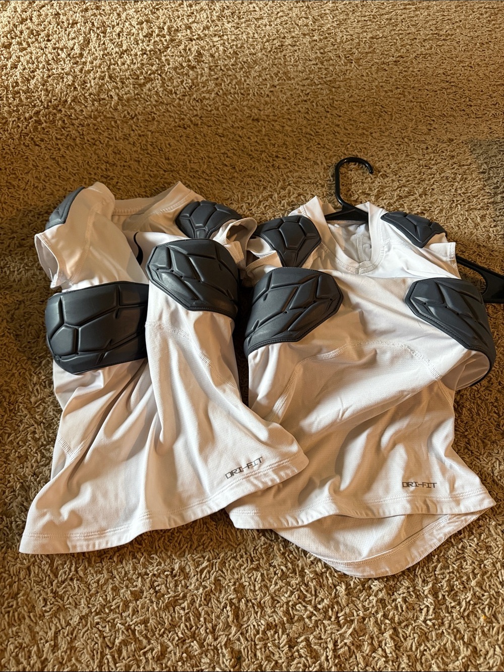 Two Nike pro white padded football Shirt with gray protective pads